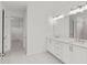 En-suite bathroom features dual sinks, a vanity, and a large, illuminated mirror at 214 Strawberry Ln, Woodstock, GA 30189