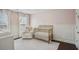 Bright Bedroom featuring a gold crib, white wainscoting, chair, and soft pink walls at 346 Ardmore Ct, Atlanta, GA 30309