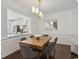 Dining room with a modern chandelier, wainscotting, hardwood floors, and an open view to the kitchen at 346 Ardmore Ct, Atlanta, GA 30309