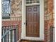 Close-up of a stylish brown front door framed by brick and stone with a black iron handrail at 346 Ardmore Ct, Atlanta, GA 30309
