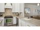 Contemporary kitchen with stainless steel appliances, marble countertops, white cabinetry, and elegant fixtures at 346 Ardmore Ct, Atlanta, GA 30309