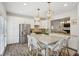 Bright kitchen with stainless steel appliances, a large island with marble countertops, and elegant brass pendant lighting at 346 Ardmore Ct, Atlanta, GA 30309