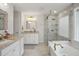 Luxurious bathroom with marble countertops, double vanities, a glass-enclosed shower, and a soaking tub at 346 Ardmore Ct, Atlanta, GA 30309