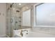 Elegant bathroom featuring a glass-enclosed shower, soaking tub with gold fixtures, and bright natural light at 346 Ardmore Ct, Atlanta, GA 30309