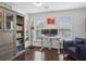 Well-lit home office with a built-in bookshelf, modern desk, and cozy blue loveseat at 346 Ardmore Ct, Atlanta, GA 30309