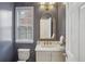 Stylish powder room with navy blue walls, a marble vanity, a decorative mirror, and modern fixtures at 346 Ardmore Ct, Atlanta, GA 30309