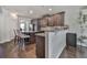 Open-concept kitchen with a center island, dark wood cabinetry, stainless steel appliances, and granite countertops at 1510 Silver Mist Cir, Powder Springs, GA 30127