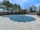 Community pool covered for the off-season, surrounded by tall trees and a green pool house at 1510 Silver Mist Cir, Powder Springs, GA 30127