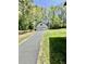 Long shot of a two car detached garage with new asphalt driveway surrounded by woods and lawn at 534 534 Shannon Way, Lawrenceville, GA 30044