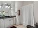 Bright bathroom boasts granite counters, white cabinetry, and a shower with curtain at 560 Brook Manor Dr, Johns Creek, GA 30022