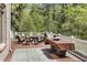 Deck offers views of the surrounding lush greenery with a table and seating area at 560 Brook Manor Dr, Johns Creek, GA 30022