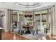 Light-filled dining room featuring a round table, elegant chairs, and large windows with woven shades at 560 Brook Manor Dr, Johns Creek, GA 30022