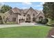 Imposing brick home showcasing manicured lawn, arched windows and a 3-car garage at 560 Brook Manor Dr, Johns Creek, GA 30022