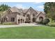 Imposing brick home showcasing manicured lawn, arched windows and a 3-car garage at 560 Brook Manor Dr, Johns Creek, GA 30022