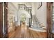 Grand foyer with hardwood floors, curved staircase, and arched doorways at 560 Brook Manor Dr, Johns Creek, GA 30022
