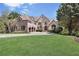 Brick home exterior with large front lawn and attached three-car garage at 560 Brook Manor Dr, Johns Creek, GA 30022