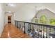 Hallway overlooking living space with hardwood floors, iron railing, and plenty of natural light at 560 Brook Manor Dr, Johns Creek, GA 30022