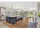 Open-concept kitchen with a large island, seating, and view to a light-filled dining area at 560 Brook Manor Dr, Johns Creek, GA 30022