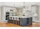 Spacious kitchen features a large island with pendant lighting and a wine rack at 560 Brook Manor Dr, Johns Creek, GA 30022