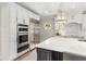 Bright kitchen features custom white cabinets, marble countertops, stainless steel appliances, and stylish lighting at 560 Brook Manor Dr, Johns Creek, GA 30022