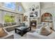 Cozy living room features a fireplace, built-in shelves and many large windows at 560 Brook Manor Dr, Johns Creek, GA 30022