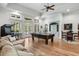 Large living room with exposed window and door access, pool table, sofa and chair seating area at 560 Brook Manor Dr, Johns Creek, GA 30022