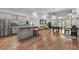 Open-concept living area with kitchen, pool table, hardwood floors, and lots of natural light at 560 Brook Manor Dr, Johns Creek, GA 30022