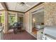 Cozy covered porch featuring brick walls, a grill, and access to the living room at 560 Brook Manor Dr, Johns Creek, GA 30022