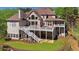 Rear exterior featuring a two-story deck, manicured lawn, and mature trees at 560 Brook Manor Dr, Johns Creek, GA 30022