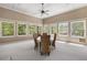 Light-filled sunroom with multiple windows, ceiling fan, and dining table set at 560 Brook Manor Dr, Johns Creek, GA 30022