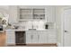 Stylish wet bar featuring white cabinetry, under-counter refrigerator, and ample storage for drinks and glassware at 560 Brook Manor Dr, Johns Creek, GA 30022