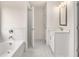 White bathroom featuring a soaking tub and white vanity, bright lighting fixtures at 7162 Linden Dr, South Fulton, GA 30349