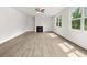A bright living room boasts light wood floors, a ceiling fan, large windows, and a cozy fireplace at 7162 Linden Dr, South Fulton, GA 30349