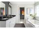 Modern bathroom with double vanity, soaking tub, marble tile, and stylish fixtures at 1984 Yellow Finch Se Trl, Atlanta, GA 30316