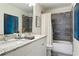 Bright bathroom with double vanity, granite countertop, framed mirrors, and a shower-tub with stylish gray tile at 1984 Yellow Finch Se Trl, Atlanta, GA 30316