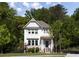 Charming two-story home with white siding and a welcoming front porch, surrounded by lush trees at 1984 Yellow Finch Se Trl, Atlanta, GA 30316
