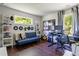 Bright and inviting home office space with a comfortable sofa, a desk setup, and views of the outside greenery at 1984 Yellow Finch Se Trl, Atlanta, GA 30316