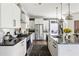 Modern kitchen with stainless steel appliances, a black granite countertop, and tile backsplash at 1984 Yellow Finch Se Trl, Atlanta, GA 30316