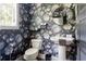Stylish powder room with floral wallpaper, a pedestal sink, and a round mirror creating a charming and elegant space at 1984 Yellow Finch Se Trl, Atlanta, GA 30316