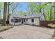 Charming white brick home with a gray roof, and a fenced-in backyard with a concrete patio area at 3915 Ivy Ne Rd, Atlanta, GA 30342