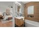 Modern bathroom featuring a stylish vanity, tiled walls, new light fixtures, with an adjacent bedroom in view at 3915 Ivy Ne Rd, Atlanta, GA 30342
