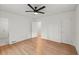 Bedroom featuring hardwood floors, ceiling fan, and ensuite bathroom with white tile at 3915 Ivy Ne Rd, Atlanta, GA 30342