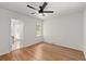 Bright bedroom has hardwood floors, ceiling fan, and a doorway to the bathroom at 3915 Ivy Ne Rd, Atlanta, GA 30342