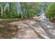Long concrete driveway leading to a two-story home with a white brick exterior surrounded by mature trees at 3915 Ivy Ne Rd, Atlanta, GA 30342