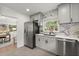 Stylish kitchen boasts gray cabinets, stainless steel appliances, granite countertops, and backsplash for a clean modern aesthetic at 3915 Ivy Ne Rd, Atlanta, GA 30342