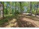 Wooded yard, framed by mature trees, leads to a charming home at 3915 Ivy Ne Rd, Atlanta, GA 30342