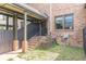 Brick house featuring covered walkway, metal stair railing, secure windows, and a small yard at 683 Pryor Sw St # C, Atlanta, GA 30315