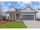 Charming craftsman-style home with gray siding, a two-car garage, and a well-manicured front lawn at 231 Strawberry Ln, Woodstock, GA 30189
