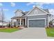Inviting craftsman home featuring a two-car garage, well-kept lawn, and gray vinyl siding at 231 Strawberry Ln, Woodstock, GA 30189