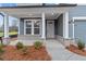 Close-up view of a craftsman-style front porch with decorative pillars and gray vinyl siding at 231 Strawberry Ln, Woodstock, GA 30189